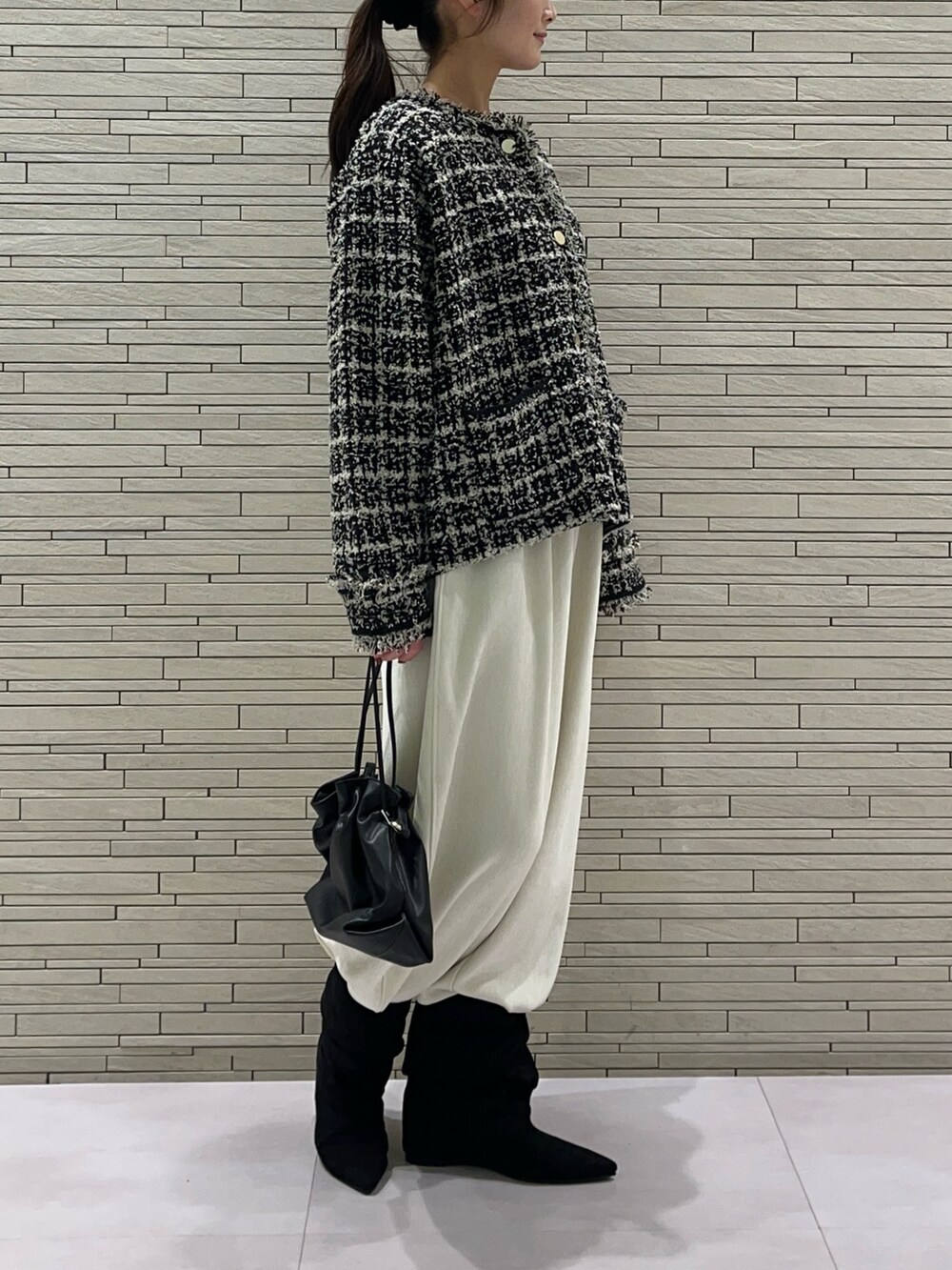 ブラック系のブルゾン、ホワイト系のその他パンツ、ブラック系のトートバッグを着用したレディースの秋コーディネートの4枚目の写真