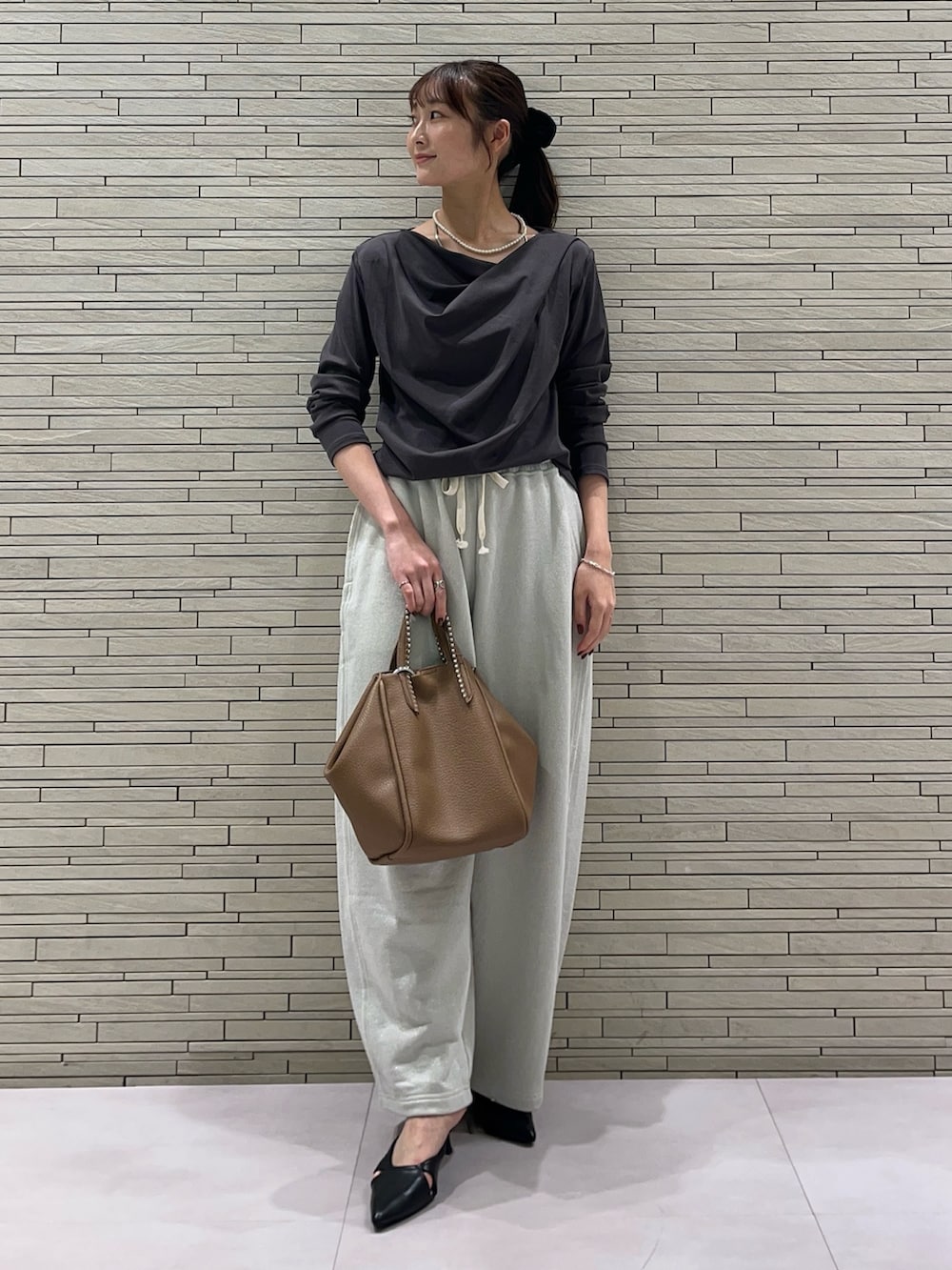 グレー系のTシャツ/カットソー、ホワイト系のスウェットパンツ、イエロー系のトートバッグを着用したレディースの秋コーディネートの4枚目の写真