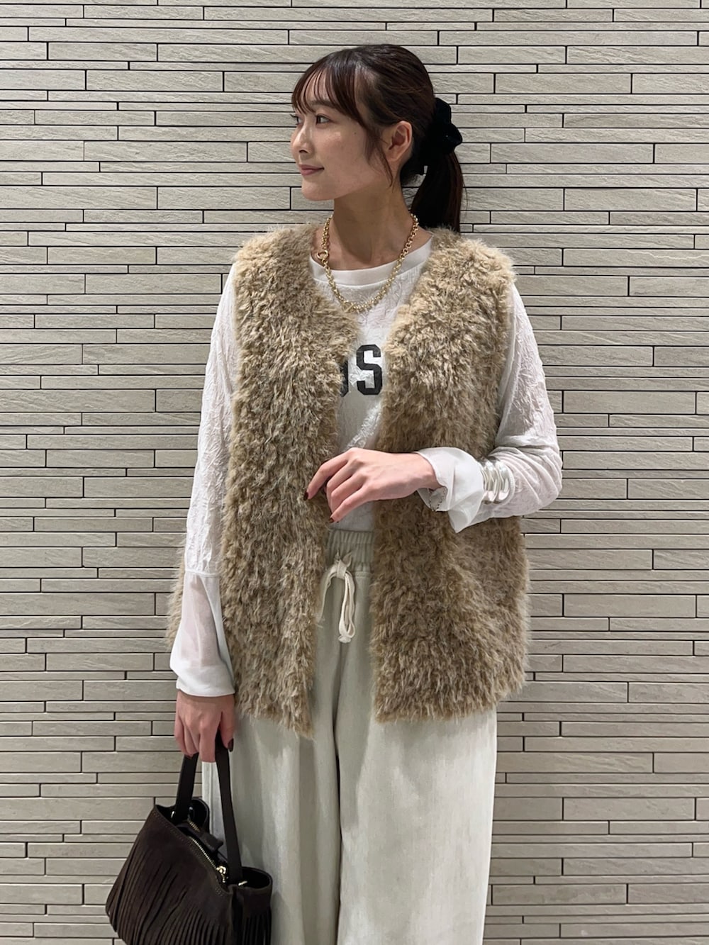 ホワイト系のその他パンツ、ブラック系のその他シューズ、ベージュ系のベストを着用したレディースの秋コーディネートの6枚目の写真