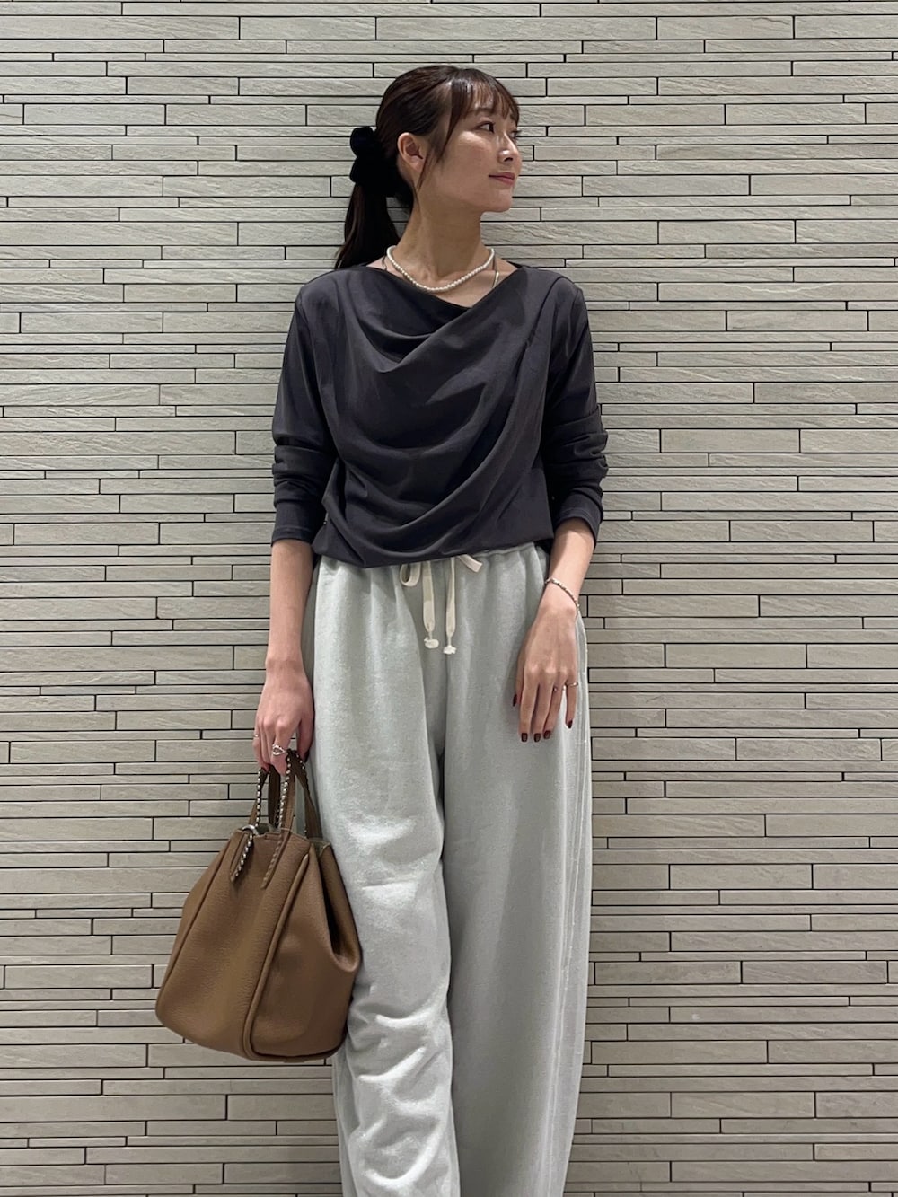グレー系のTシャツ/カットソー、ホワイト系のスウェットパンツ、イエロー系のトートバッグを着用したレディースの秋コーディネートの3枚目の写真