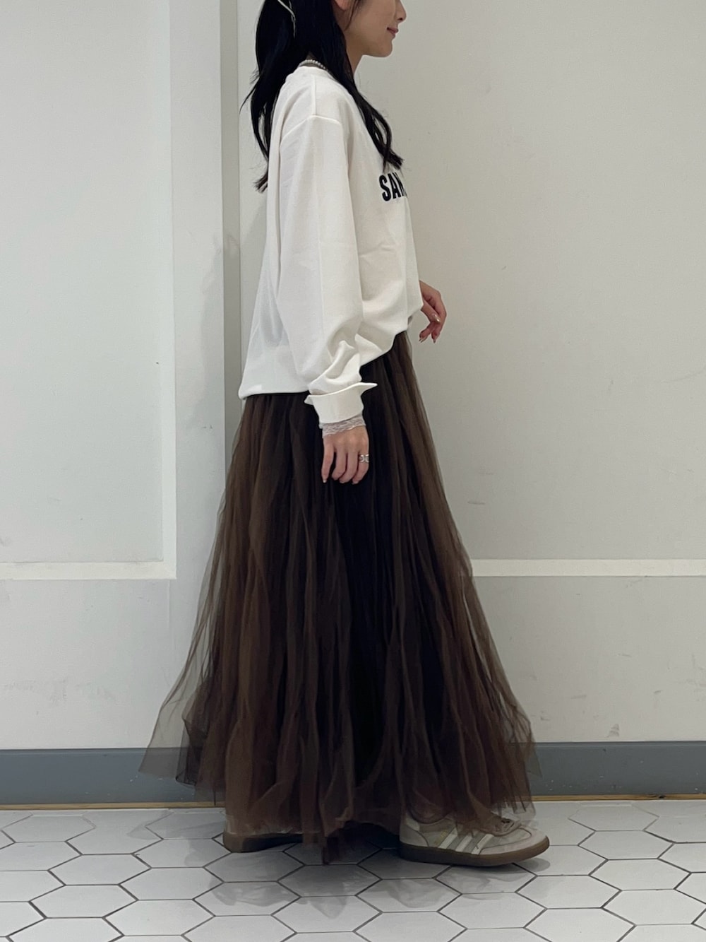 ホワイト系のシャツ/ブラウス、ブラウン系のスカート、ホワイト系のTシャツ/カットソーを着用したレディースの秋コーディネートの3枚目の写真