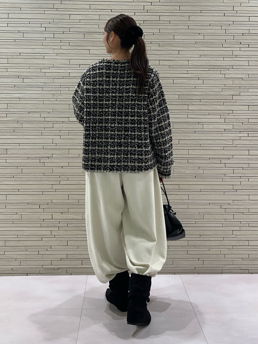 ブラック系のブルゾン、ホワイト系のその他パンツ、ブラック系のトートバッグを着用したレディースの秋コーディネートの5枚目の写真