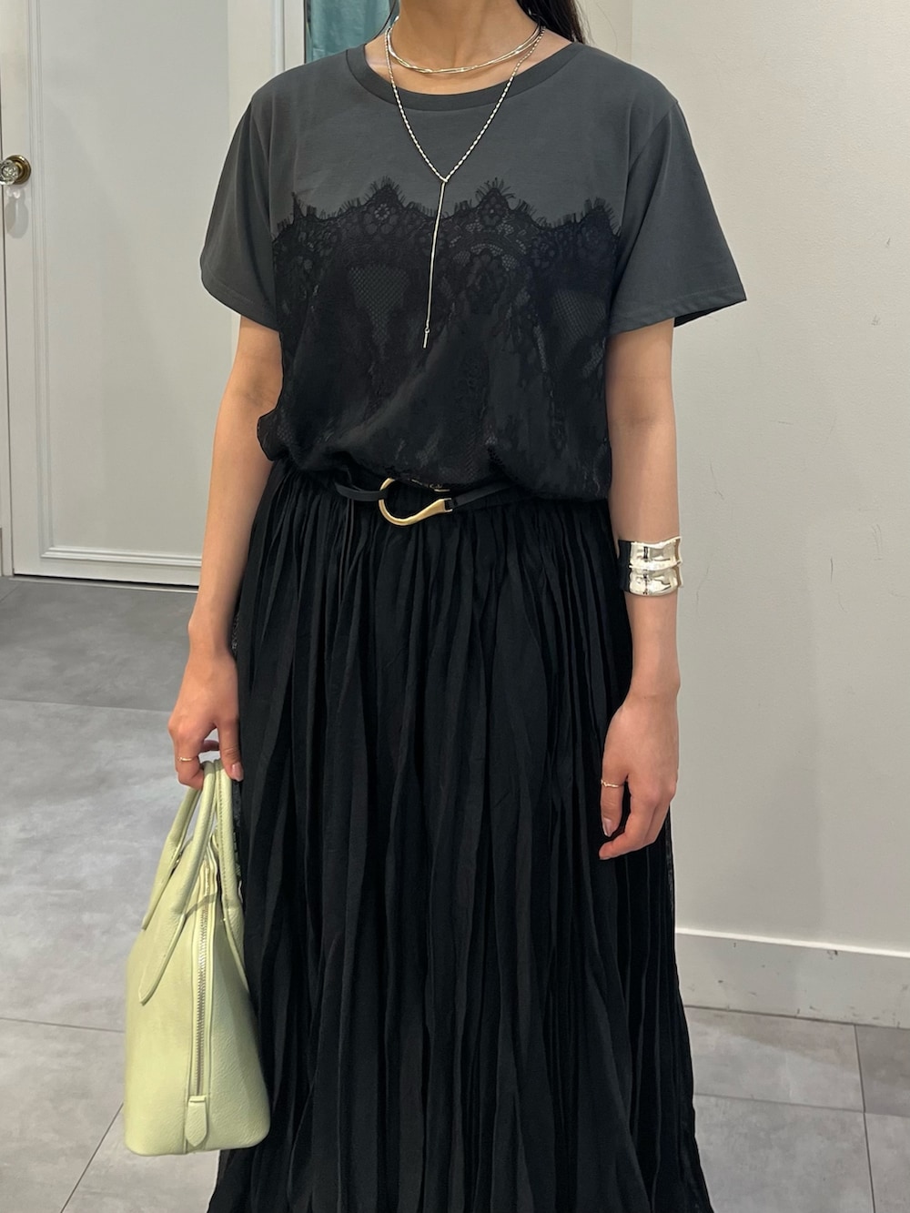 グリーン系のショルダーバッグ、グレー系のTシャツ/カットソー、シルバー系のその他シューズを着用したレディースの夏コーディネートの4枚目の写真