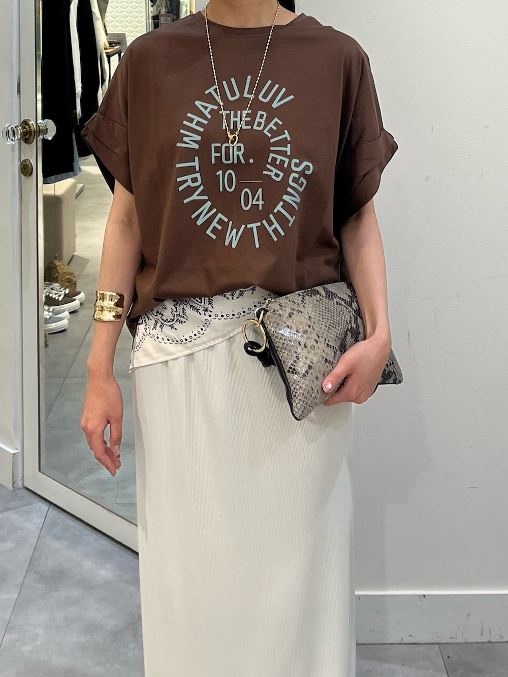 ブラウン系のTシャツ/カットソー、ホワイト系のスカート、ホワイト系のストール/ショールを着用したレディースの夏コーディネートの2枚目の写真