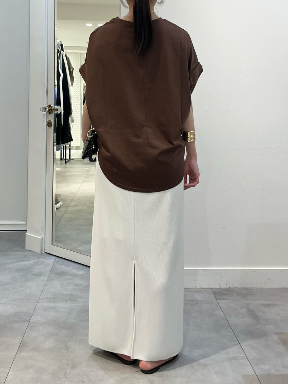 ブラウン系のTシャツ/カットソー、ホワイト系のスカート、ホワイト系のストール/ショールを着用したレディースの夏コーディネートの4枚目の写真