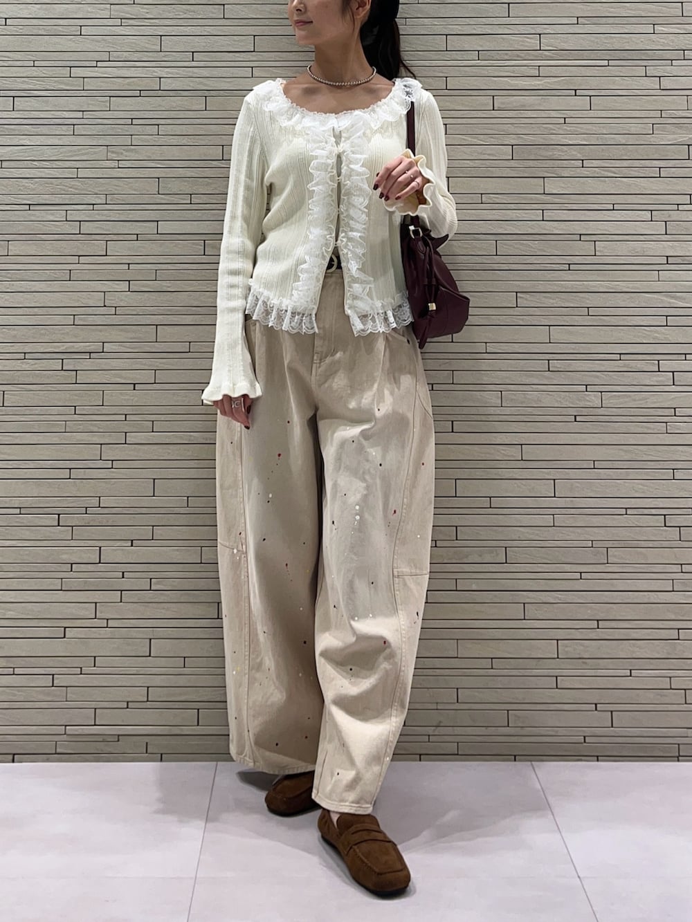 ホワイト系のカーディガン/ボレロ、ベージュ系のその他パンツ、レッド系のトートバッグを着用したレディースの秋コーディネートの3枚目の写真