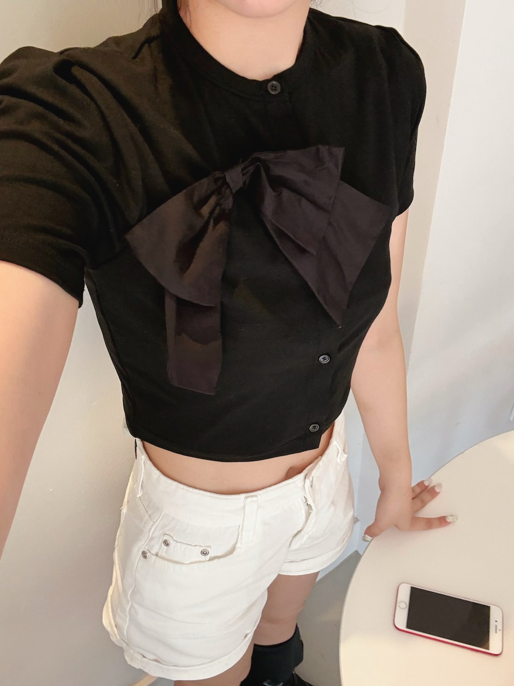 ブラック系のトップス、ホワイト系のデニムパンツを着用したレディースの夏コーディネートの2枚目の写真