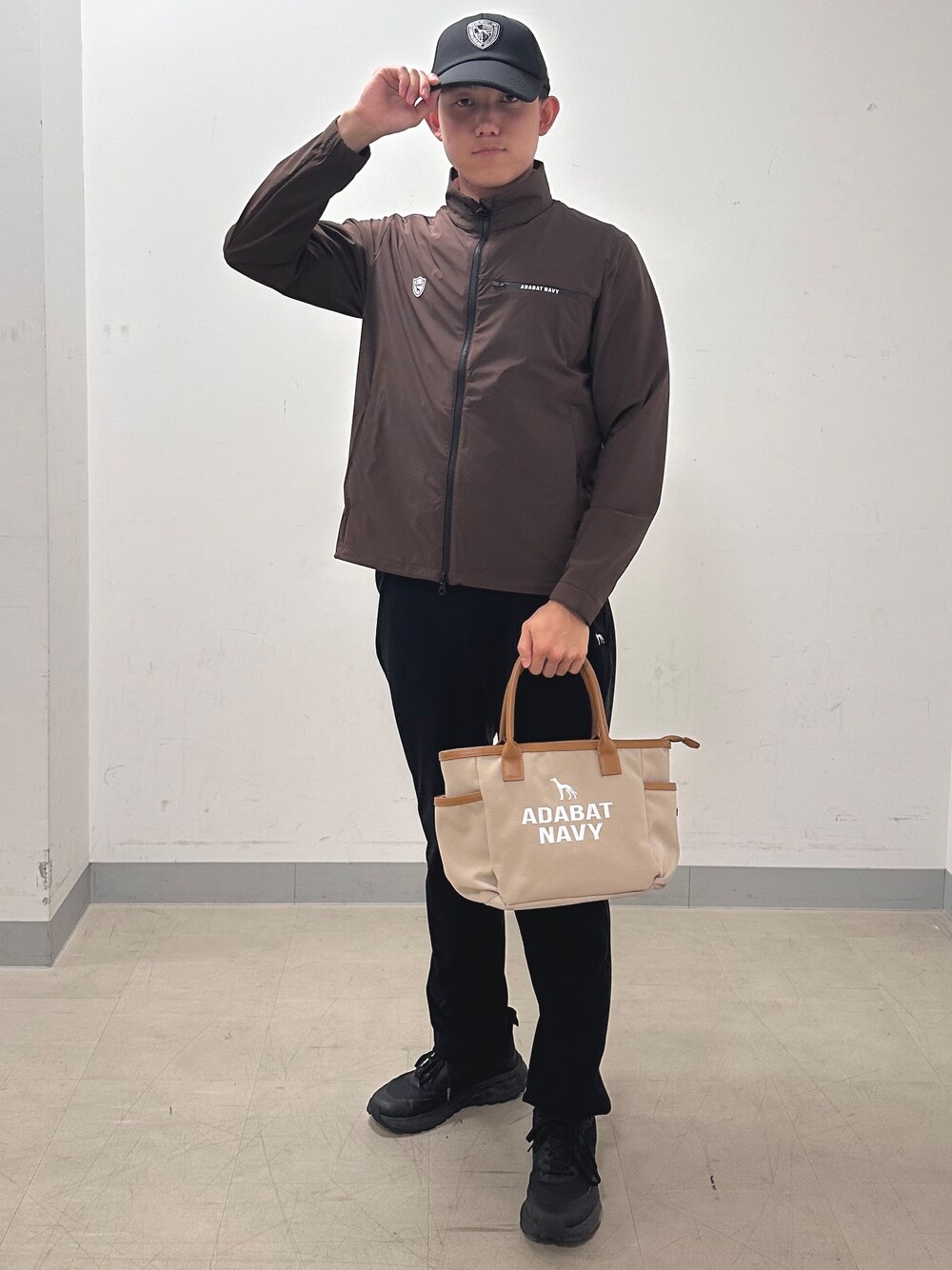 ブラック系のその他パンツ、ベージュ系のトートバッグ、ブラウン系のブルゾンを着用したメンズの秋コーディネートの5枚目の写真