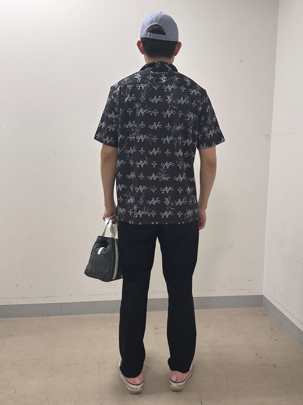 ブルー系のポロシャツ、ブラック系のその他パンツ、グレー系のキャップを着用したメンズの夏コーディネートの3枚目の写真