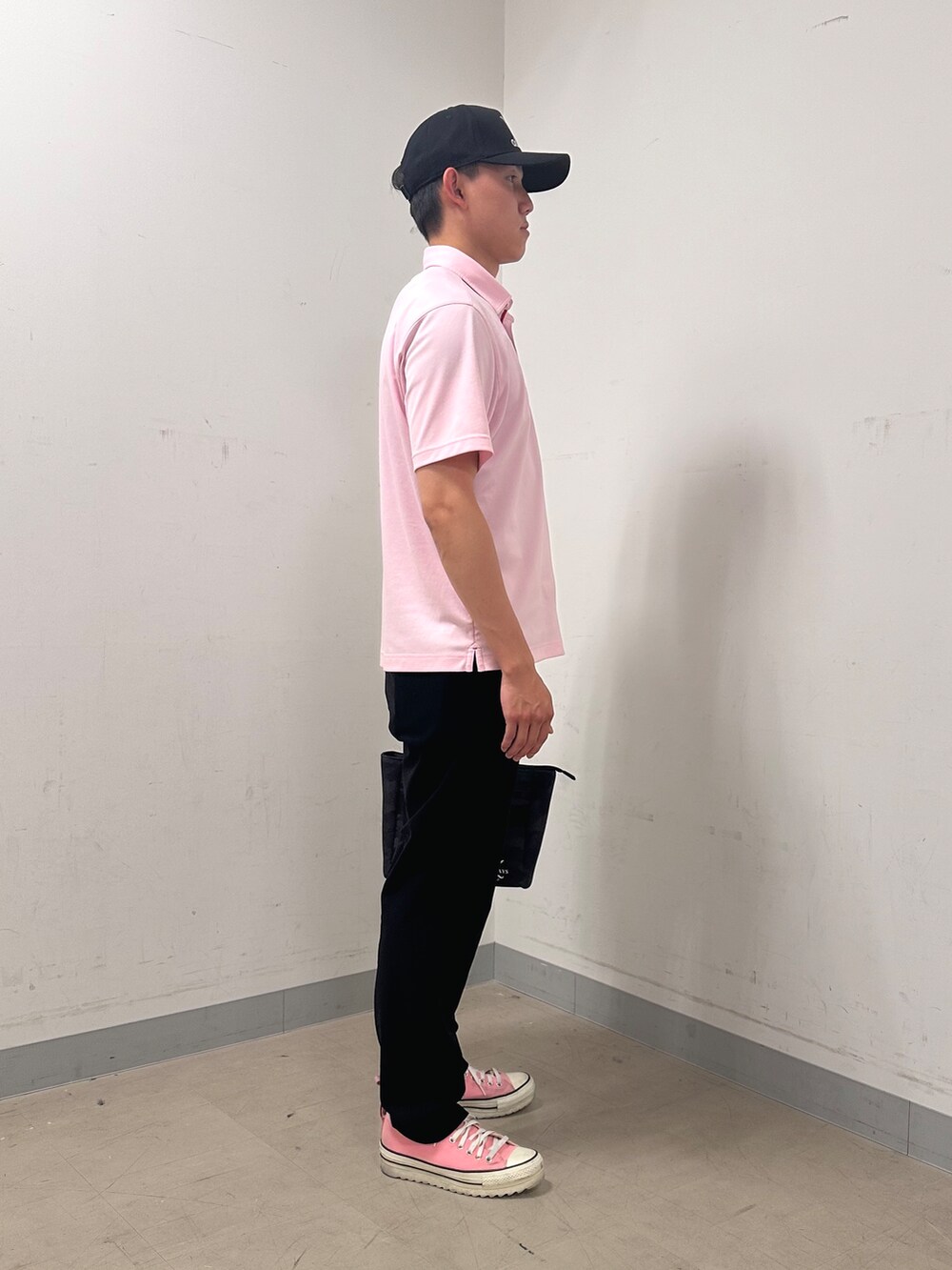 ピンク系のポロシャツ、ブラック系のその他パンツ、ブラック系のトートバッグを着用したメンズの夏コーディネートの4枚目の写真