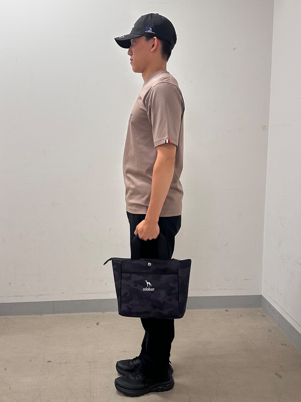 ブラウン系のTシャツ/カットソー、ブラック系のその他パンツ、ブラック系のトートバッグを着用したメンズの夏コーディネートの2枚目の写真