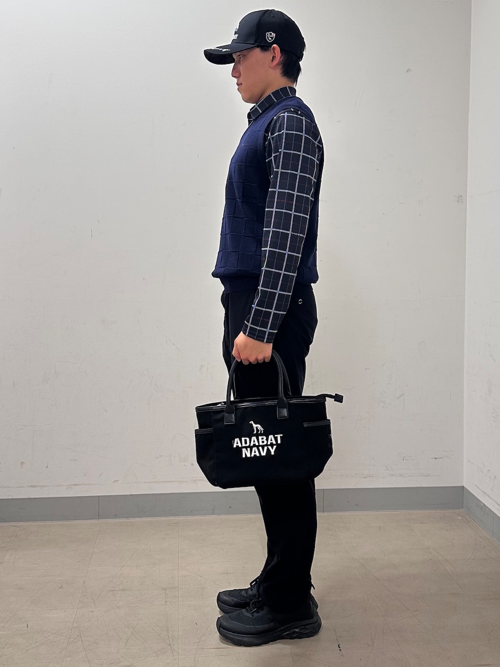 ブルー系のポロシャツ、ブラック系のその他パンツ、ブラック系のトートバッグを着用したメンズの秋コーディネートの2枚目の写真