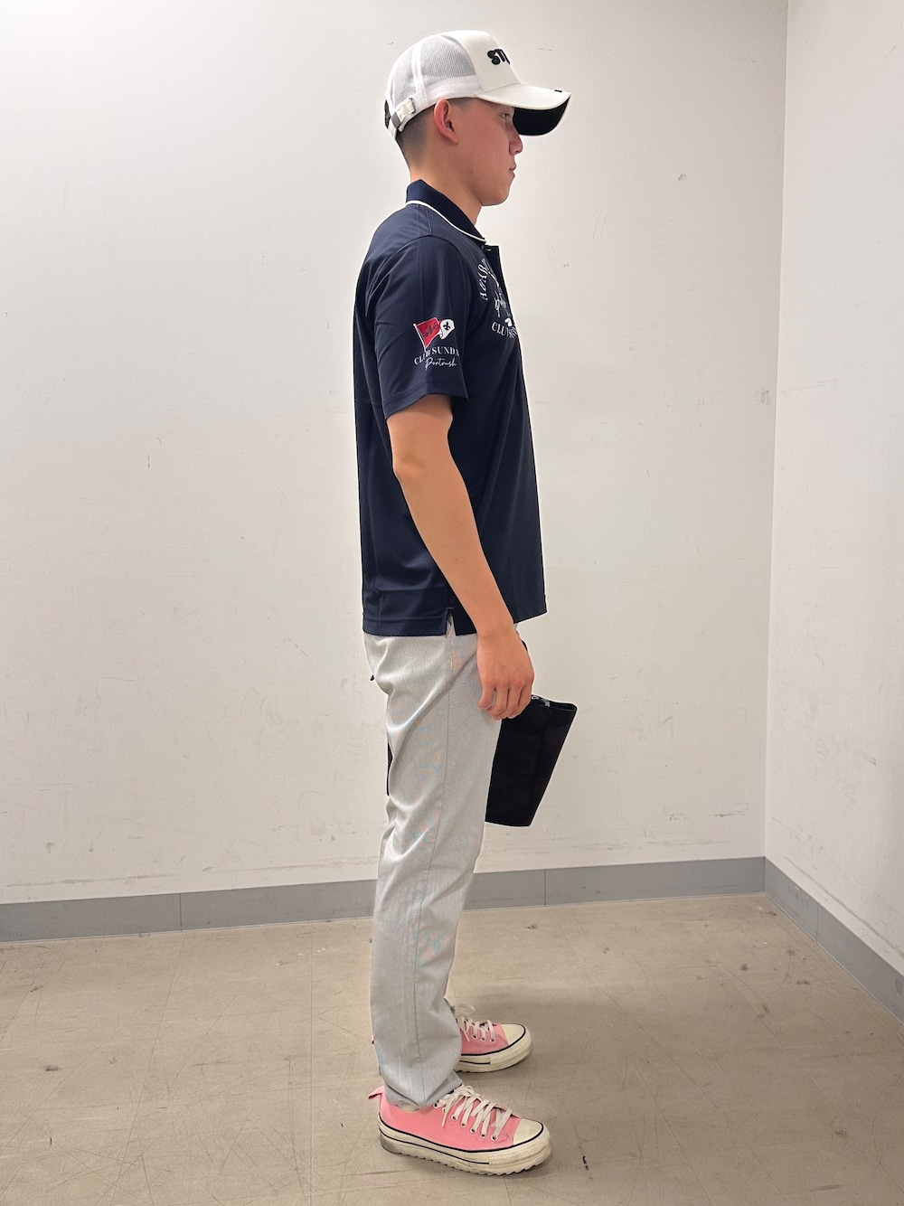 ブルー系のポロシャツ、グレー系のその他パンツ、ブラック系のトートバッグを着用したメンズの夏コーディネートの4枚目の写真