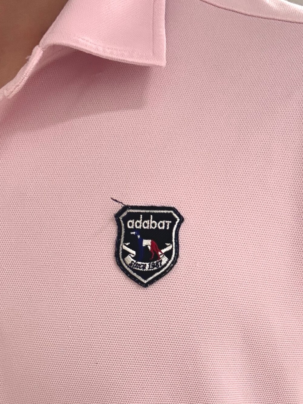 ピンク系のポロシャツ、グレー系のその他パンツ、ブラック系のキャップを着用したメンズの夏コーディネートの5枚目の写真