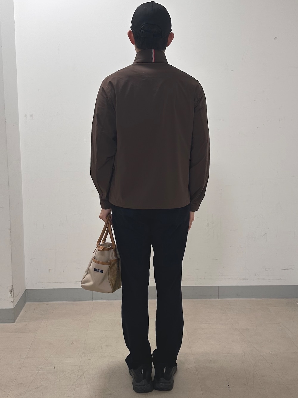 ブラック系のその他パンツ、ベージュ系のトートバッグ、ブラウン系のブルゾンを着用したメンズの秋コーディネートの3枚目の写真