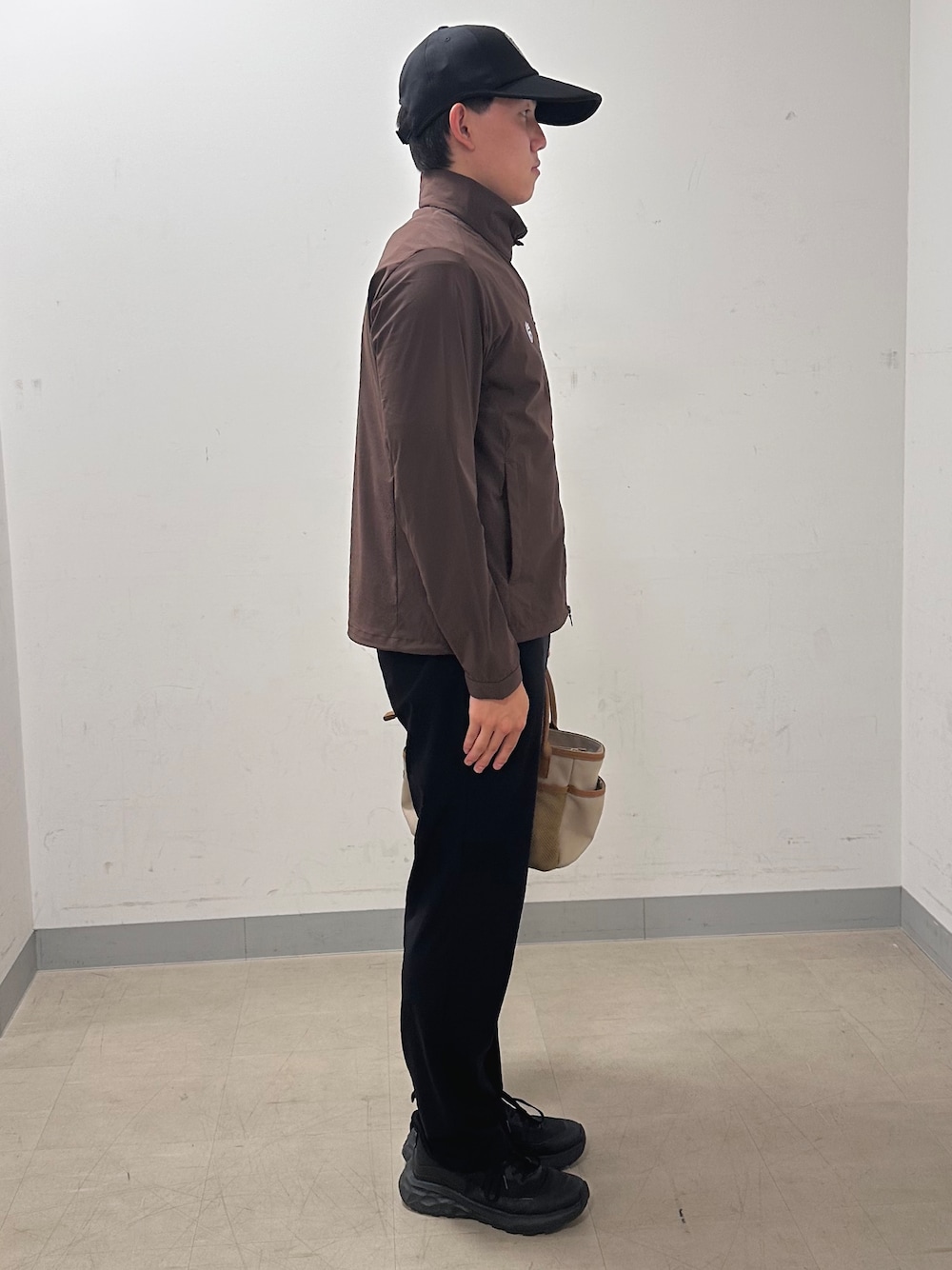ブラック系のその他パンツ、ベージュ系のトートバッグ、ブラウン系のブルゾンを着用したメンズの秋コーディネートの4枚目の写真