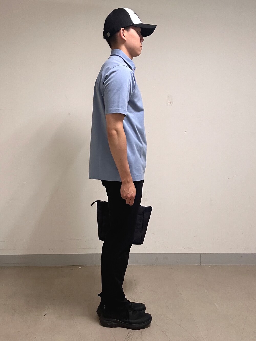 ブルー系のポロシャツ、グレー系のその他パンツ、ブラック系のトートバッグを着用したメンズの夏コーディネートの4枚目の写真