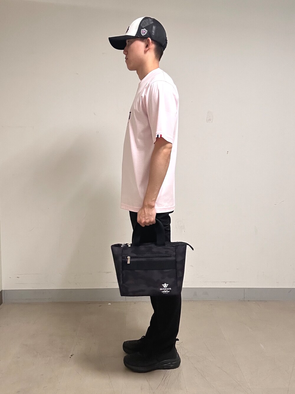 ピンク系のTシャツ/カットソー、ブラック系のその他パンツ、ブラック系のトートバッグを着用したメンズの夏コーディネートの2枚目の写真