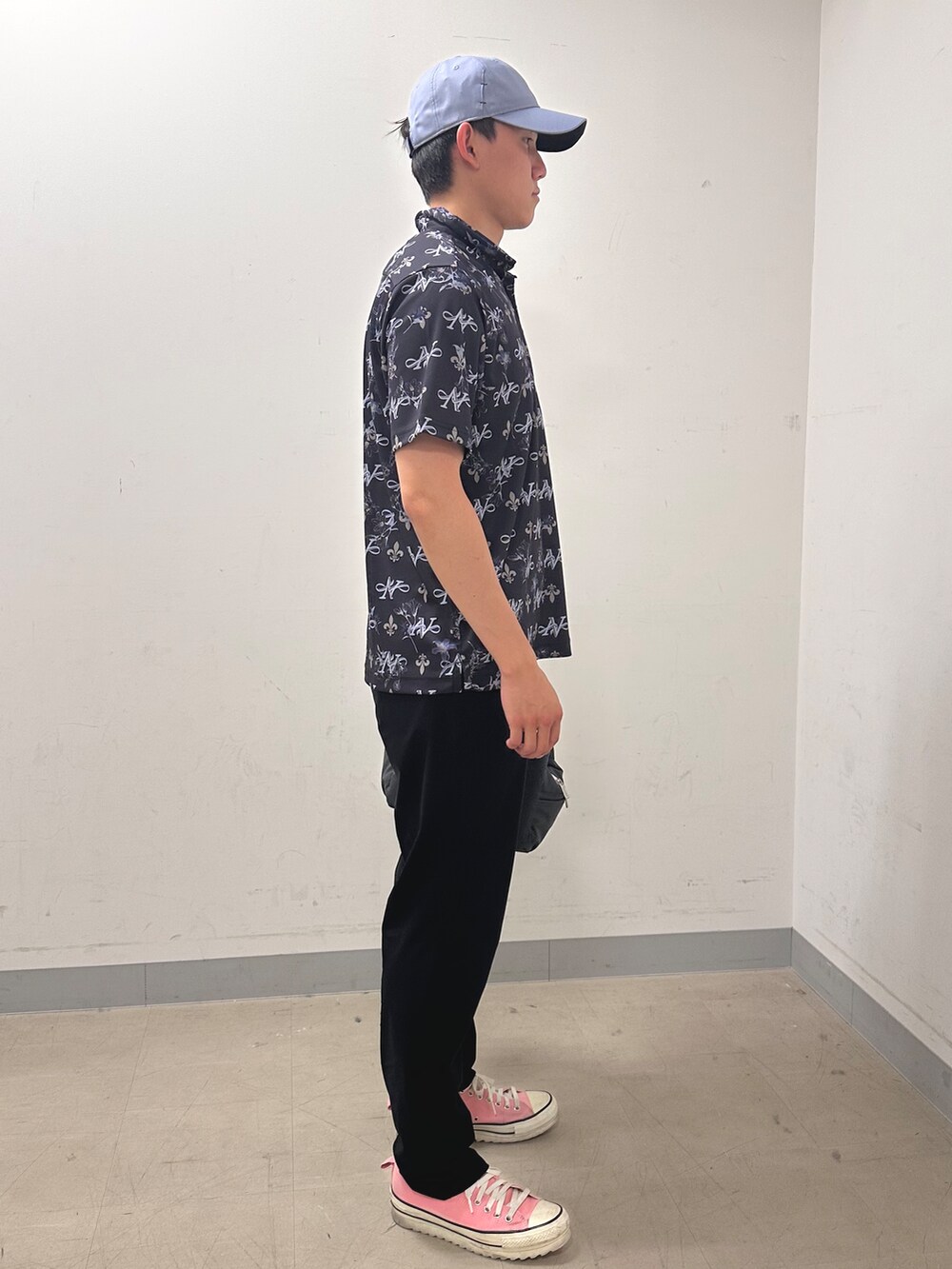 ブルー系のポロシャツ、ブラック系のその他パンツ、グレー系のキャップを着用したメンズの夏コーディネートの4枚目の写真