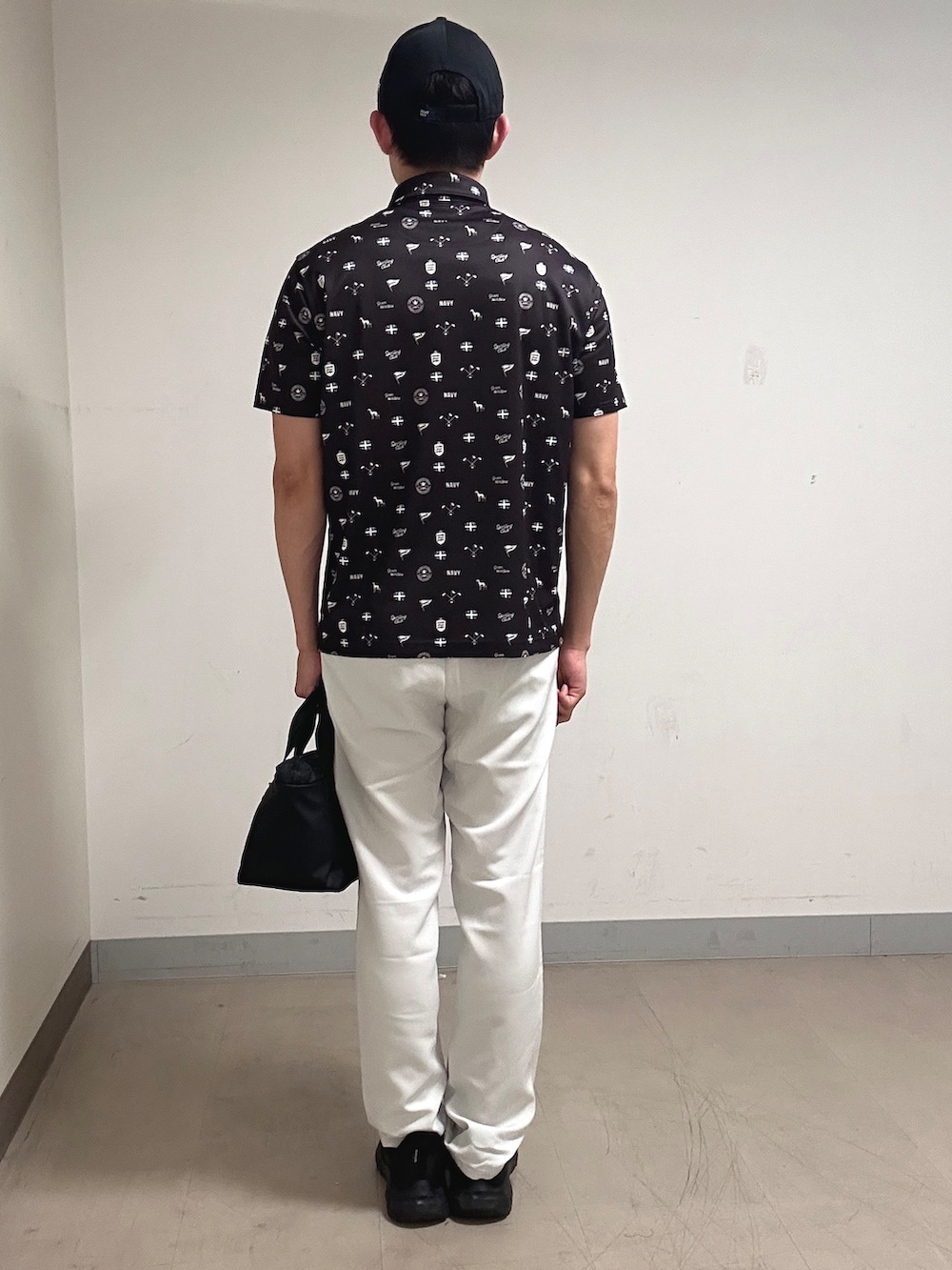 ブラウン系のポロシャツ、グレー系のその他パンツ、ブラック系のキャップを着用したメンズの夏コーディネートの3枚目の写真