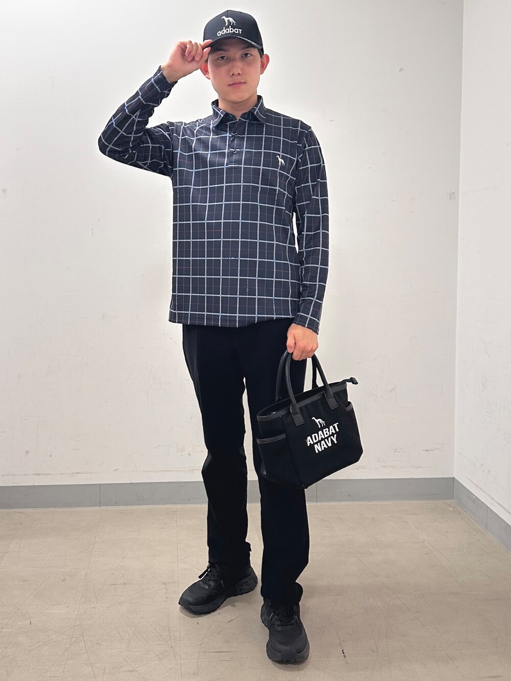 ブルー系のポロシャツ、ブラック系のその他パンツ、ブラック系のトートバッグを着用したメンズの秋コーディネートの5枚目の写真
