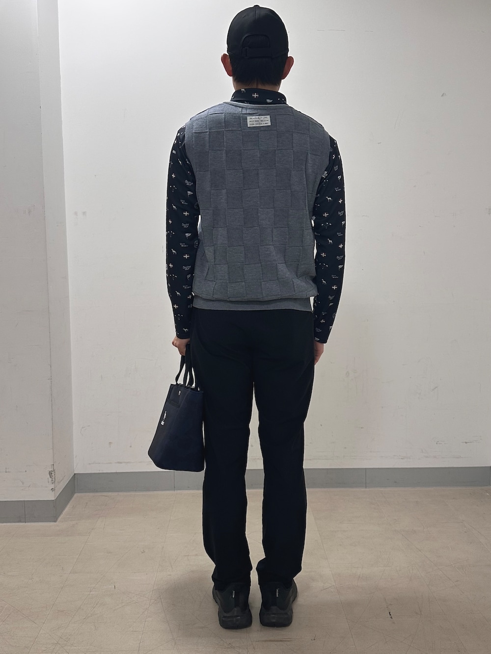 ブルー系のポロシャツ、ブラック系のその他パンツ、ブルー系のトートバッグを着用したメンズの秋コーディネートの3枚目の写真