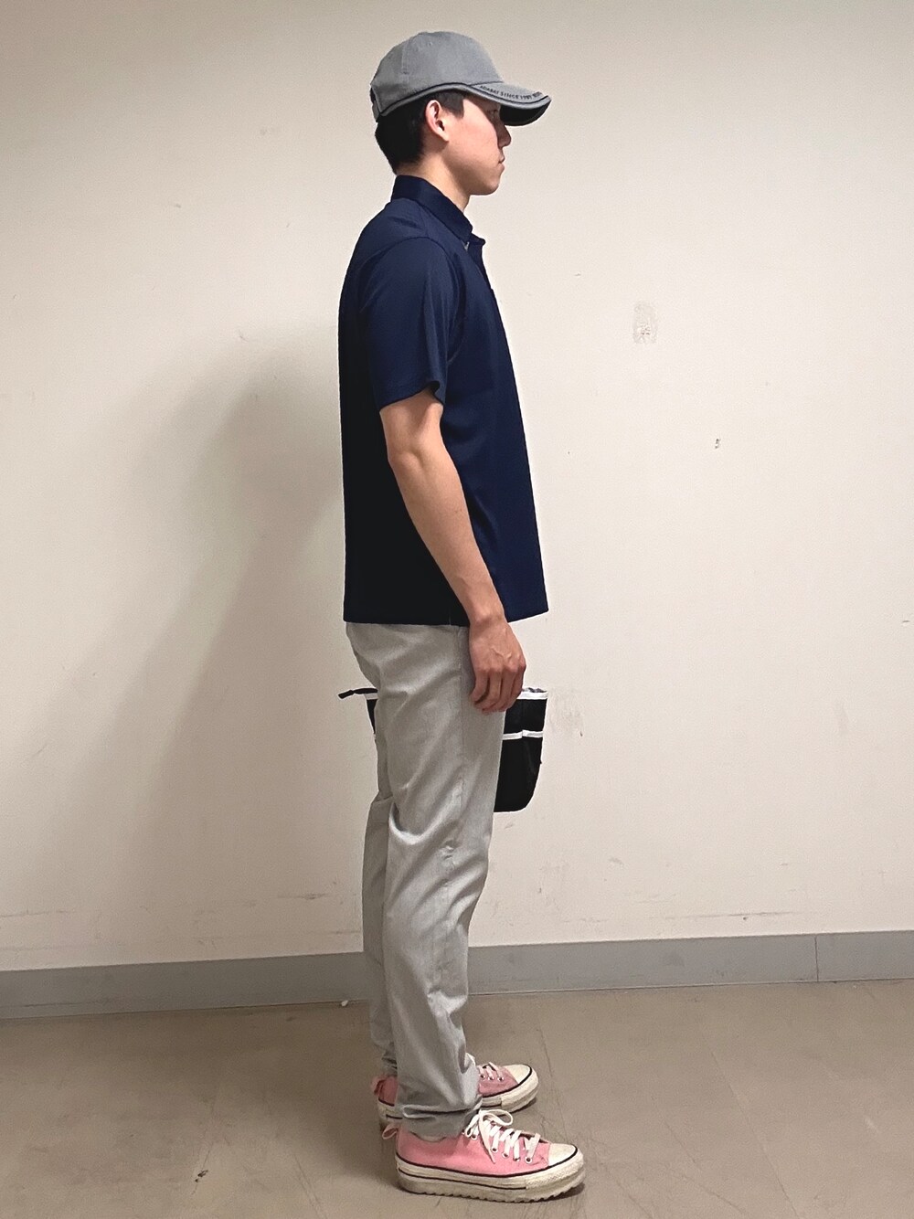 ブルー系のポロシャツ、グレー系のその他パンツ、ブラック系のトートバッグを着用したメンズの夏コーディネートの4枚目の写真
