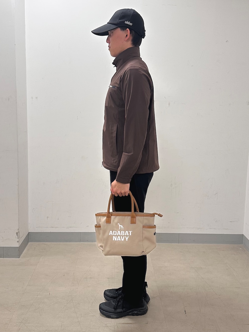 ブラック系のその他パンツ、ベージュ系のトートバッグ、ブラウン系のブルゾンを着用したメンズの秋コーディネートの2枚目の写真