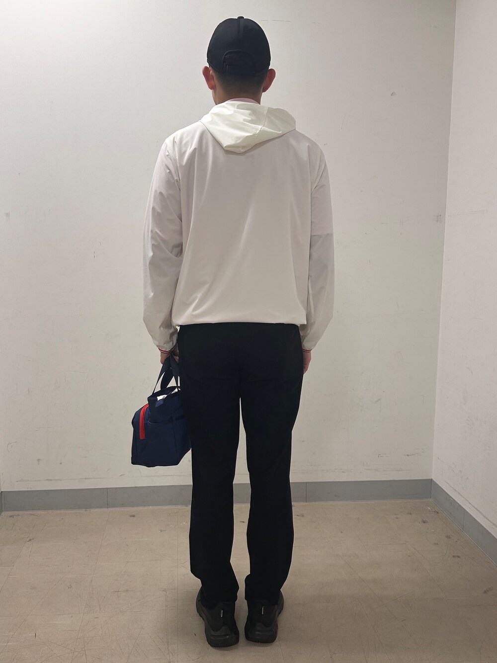 ホワイト系のブルゾン、ブラック系のその他パンツ、ブルー系のトートバッグを着用したメンズの夏コーディネートの3枚目の写真