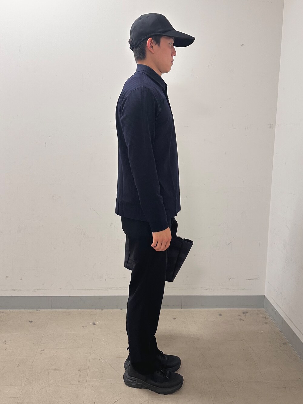 ブルー系のポロシャツ、ブラック系のその他パンツ、ブラック系のトートバッグを着用したメンズの秋コーディネートの4枚目の写真