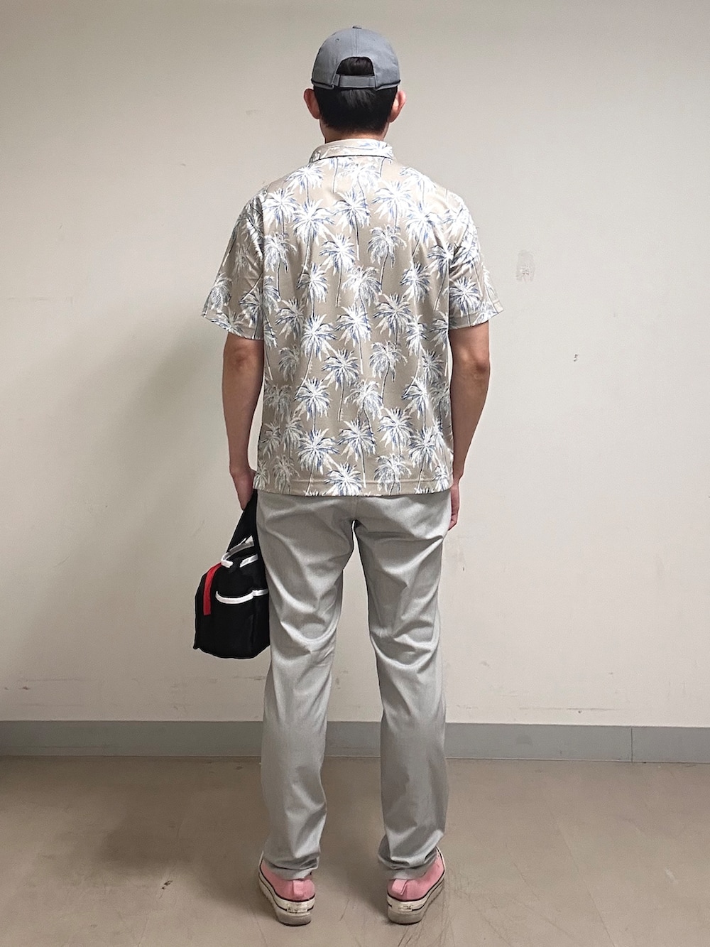 ホワイト系のポロシャツ、グレー系のその他パンツ、ブラック系のトートバッグを着用したメンズの夏コーディネートの3枚目の写真
