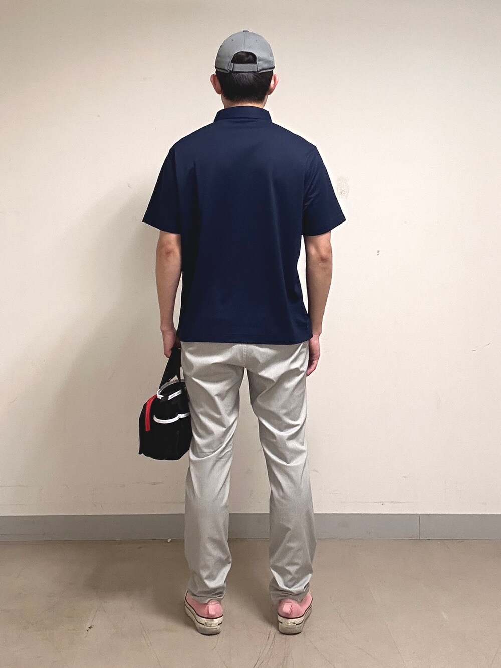 ブルー系のポロシャツ、グレー系のその他パンツ、ブラック系のトートバッグを着用したメンズの夏コーディネートの3枚目の写真