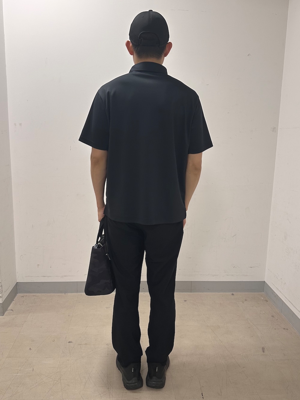 ブラック系のポロシャツ、ブラック系のその他パンツ、ブラック系のトートバッグを着用したメンズの夏コーディネートの3枚目の写真