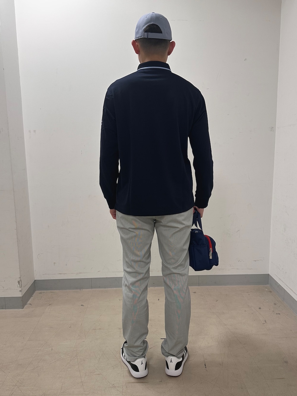 ブルー系のポロシャツ、グレー系のその他パンツ、ブルー系のトートバッグを着用したメンズの夏コーディネートの3枚目の写真