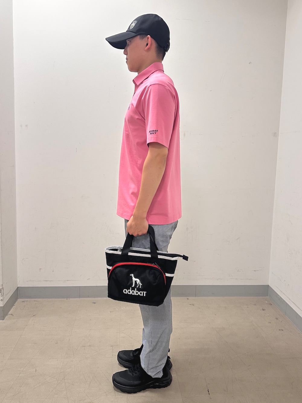 ピンク系のポロシャツ、グレー系のその他パンツ、ブルー系のトートバッグを着用したメンズの夏コーディネートの2枚目の写真