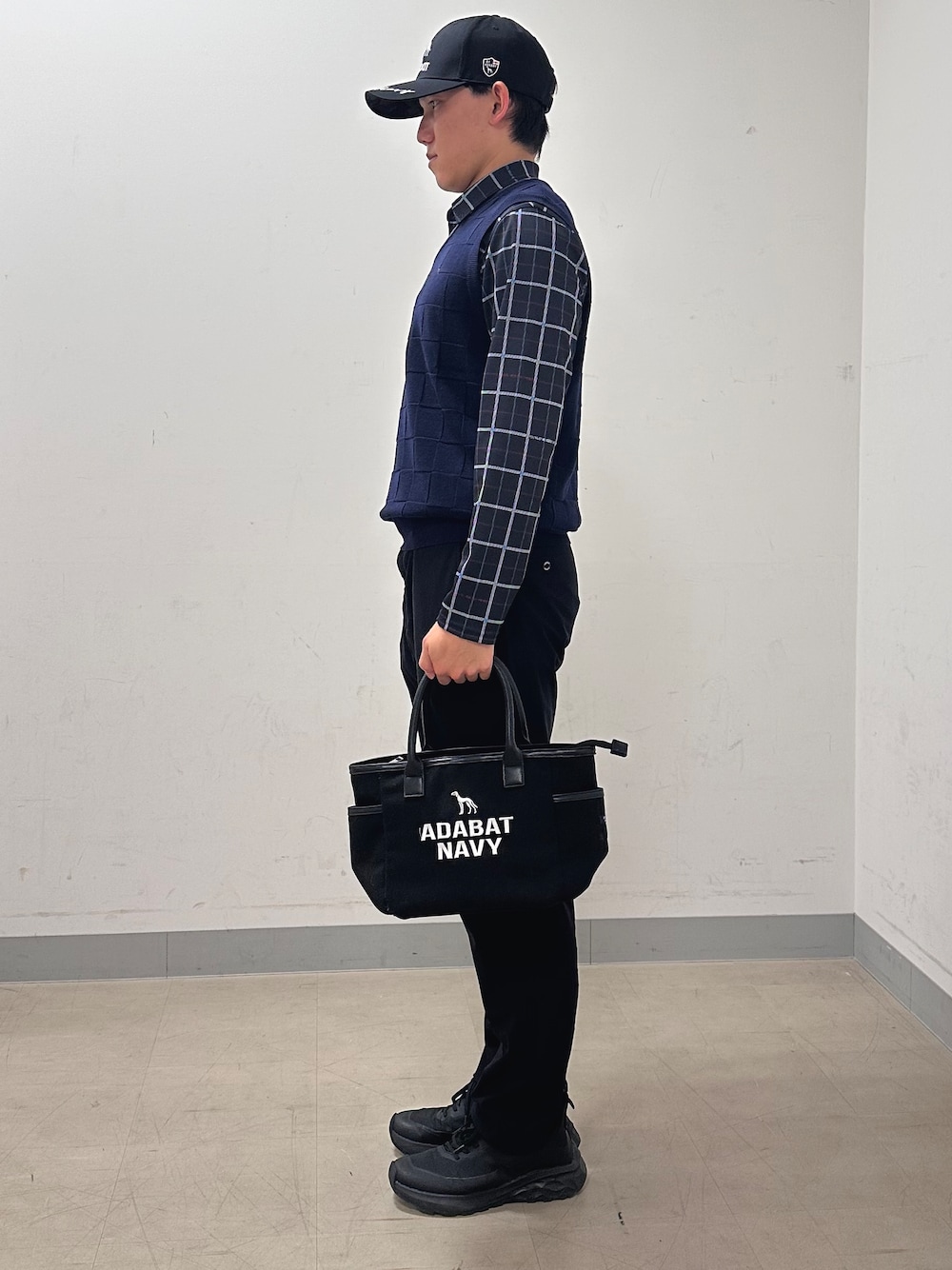 ブルー系のポロシャツ、ブラック系のその他パンツ、ブラック系のトートバッグを着用したメンズの秋コーディネートの2枚目の写真
