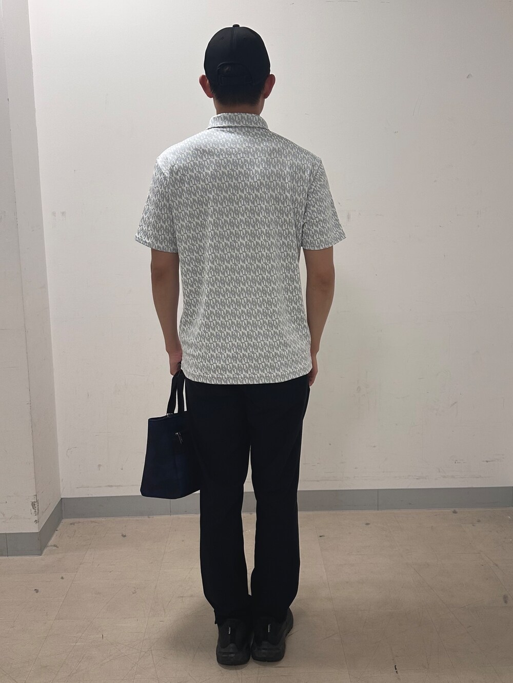 グレー系のポロシャツ、ブラック系のその他パンツ、ブルー系のトートバッグを着用したメンズの夏コーディネートの3枚目の写真