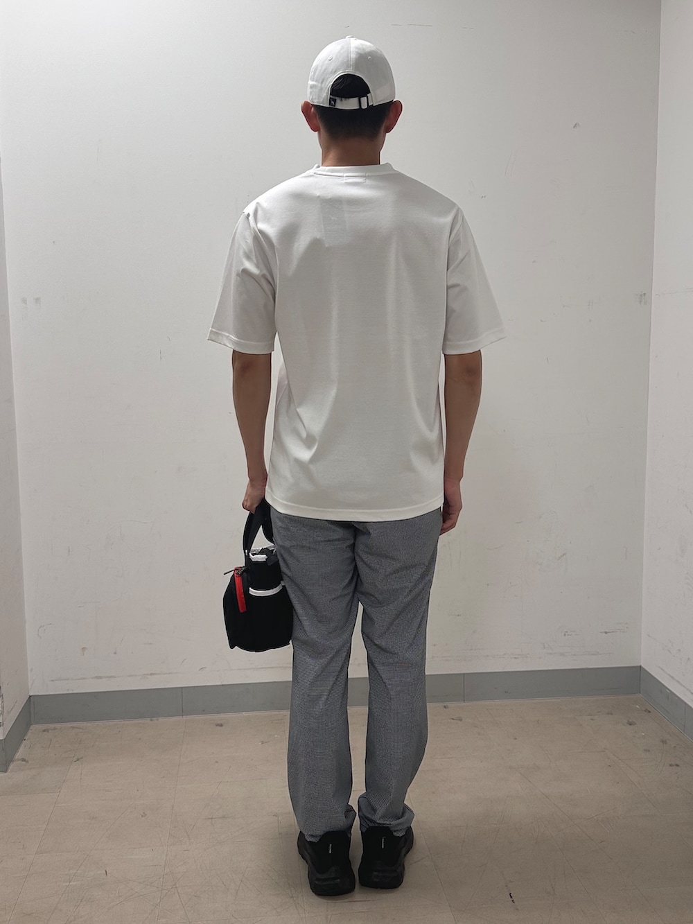 ホワイト系のTシャツ/カットソー、グレー系のその他パンツ、ブラック系のトートバッグを着用したメンズの夏コーディネートの3枚目の写真