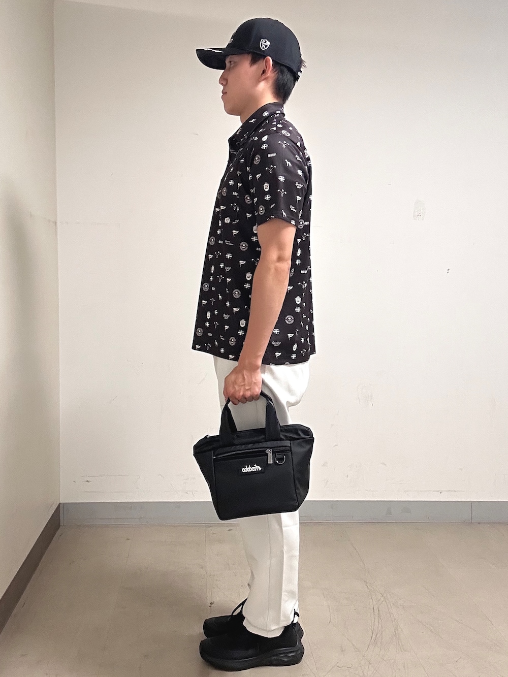 ブラウン系のポロシャツ、グレー系のその他パンツ、ブラック系のキャップを着用したメンズの夏コーディネートの2枚目の写真