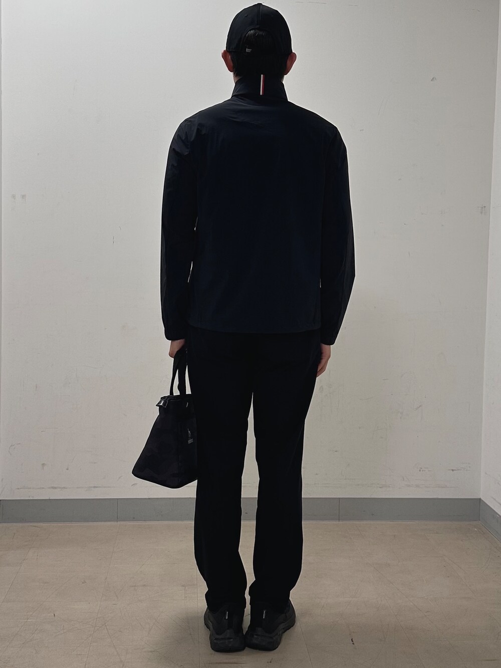 ブラック系のブルゾン、ブラック系のその他パンツ、ブラック系のトートバッグを着用したメンズの秋コーディネートの3枚目の写真