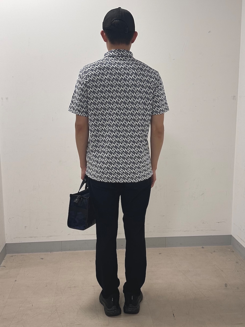 ブルー系のポロシャツ、ブラック系のその他パンツ、ブルー系のトートバッグを着用したメンズの夏コーディネートの3枚目の写真