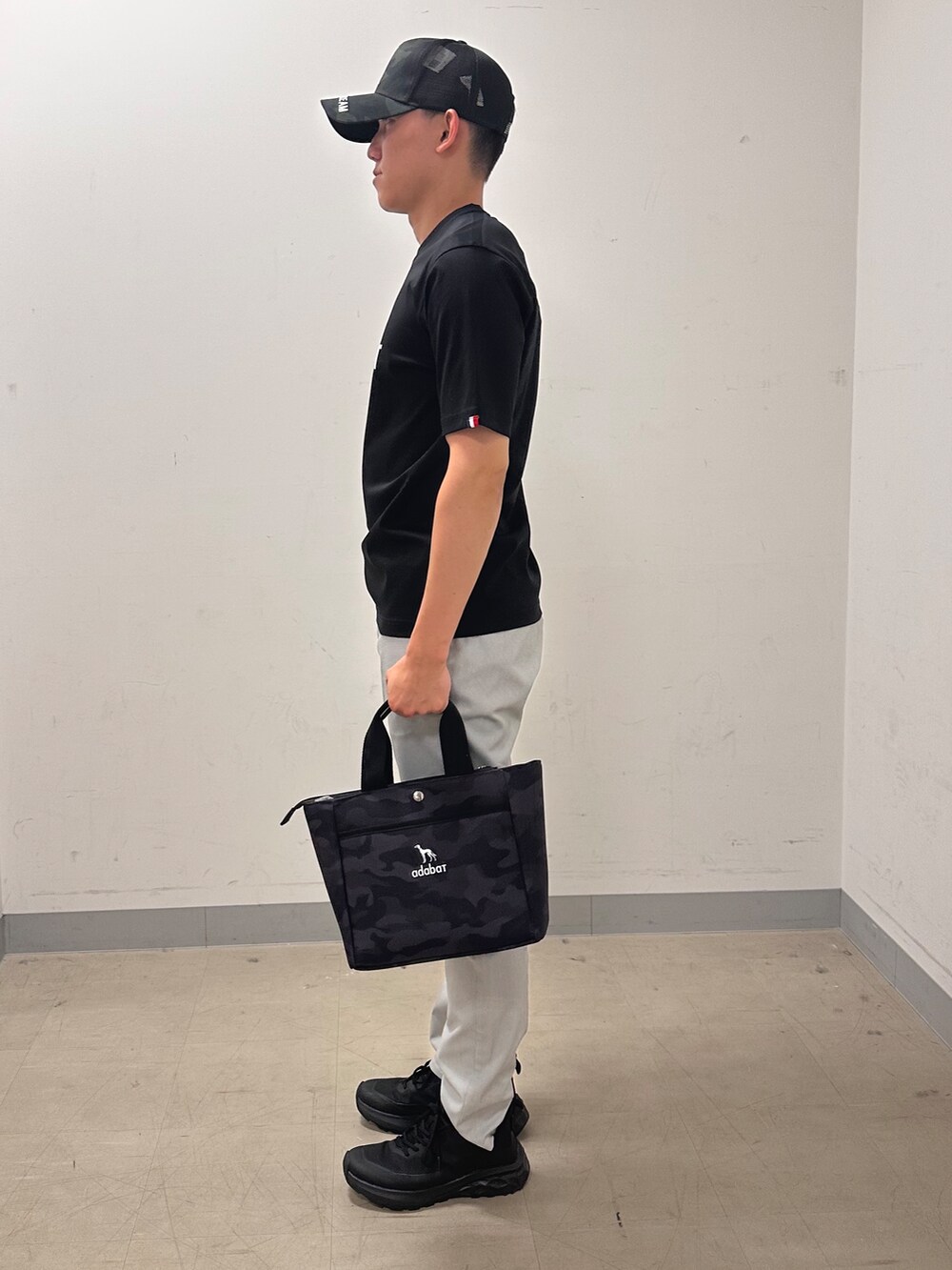ブラック系のTシャツ/カットソー、グレー系のその他パンツ、ブラック系のトートバッグを着用したメンズの夏コーディネートの2枚目の写真