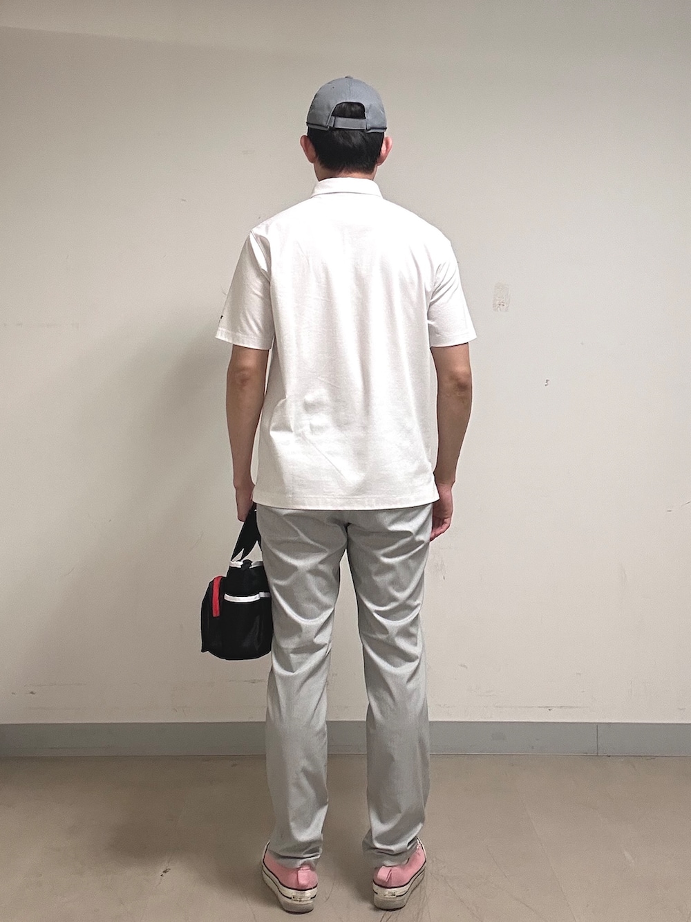ホワイト系のポロシャツ、グレー系のその他パンツ、ブラック系のトートバッグを着用したメンズの夏コーディネートの4枚目の写真
