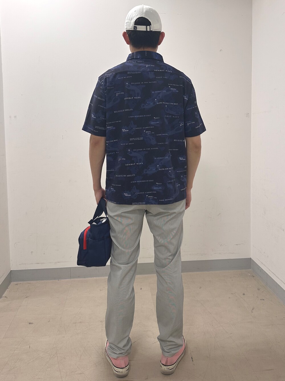 ブルー系のポロシャツ、グレー系のその他パンツ、ブルー系のトートバッグを着用したメンズの夏コーディネートの3枚目の写真