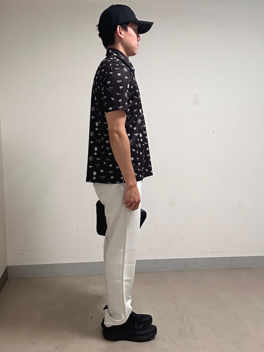 ブラウン系のポロシャツ、グレー系のその他パンツ、ブラック系のキャップを着用したメンズの夏コーディネートの4枚目の写真