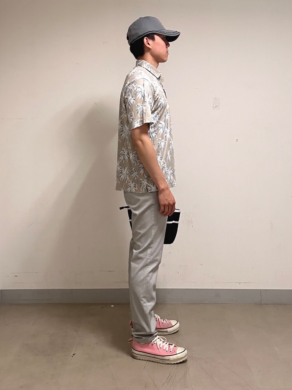 ホワイト系のポロシャツ、グレー系のその他パンツ、ブラック系のトートバッグを着用したメンズの夏コーディネートの2枚目の写真