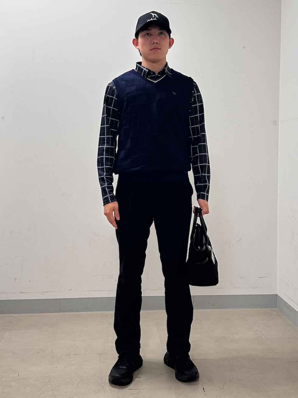 ブルー系のポロシャツ、ブラック系のその他パンツ、ブラック系のトートバッグを着用したメンズの秋コーディネートの5枚目の写真