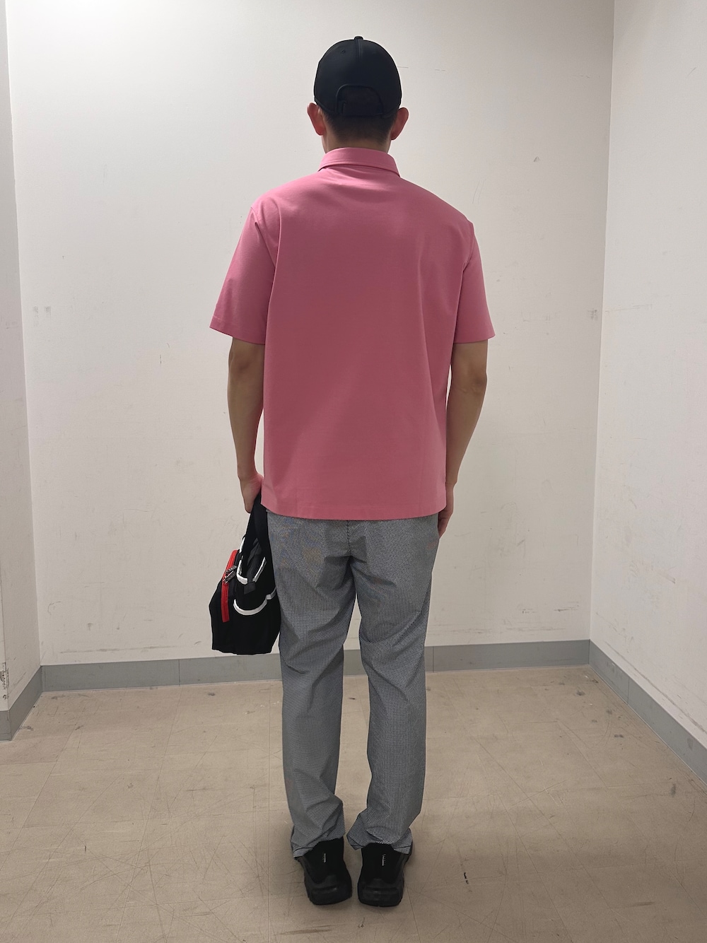 ピンク系のポロシャツ、グレー系のその他パンツ、ブルー系のトートバッグを着用したメンズの夏コーディネートの3枚目の写真