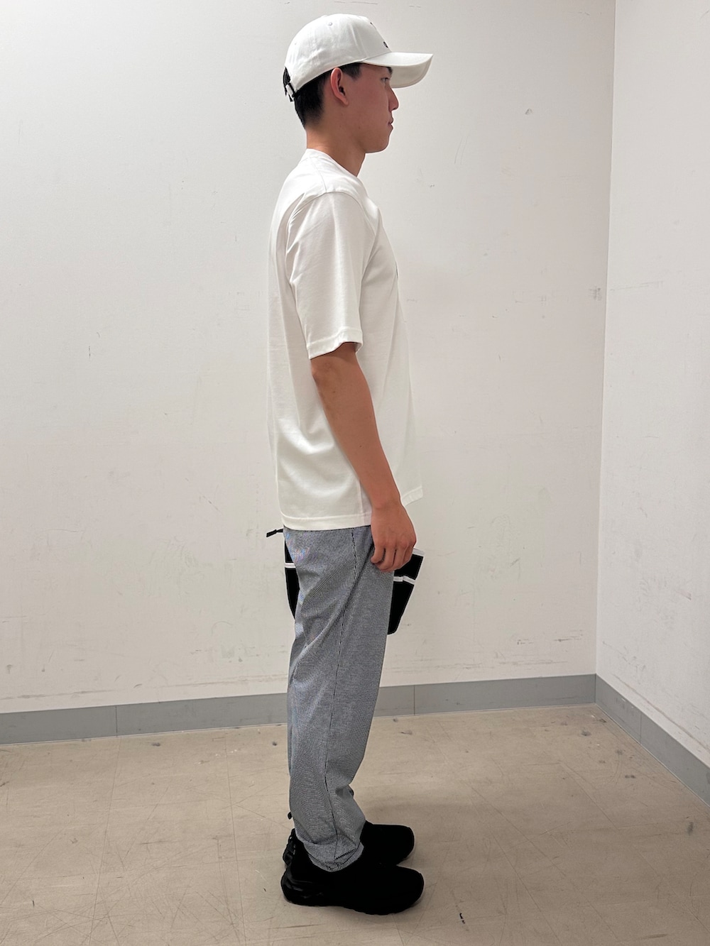 ホワイト系のTシャツ/カットソー、グレー系のその他パンツ、ブラック系のトートバッグを着用したメンズの夏コーディネートの4枚目の写真