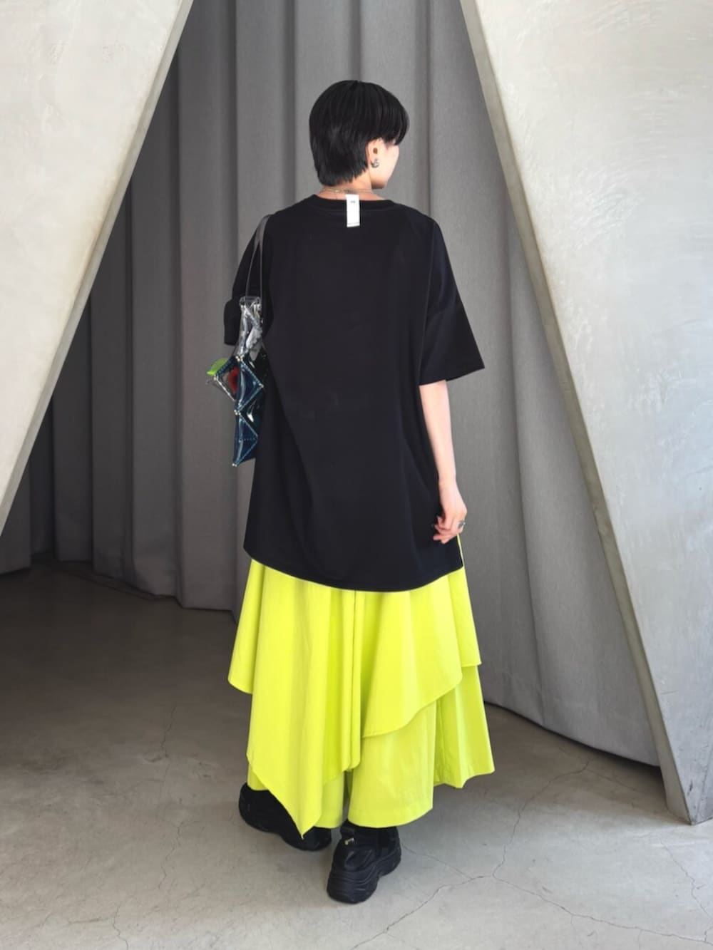 ブラック系のTシャツ/カットソー、イエロー系のその他パンツ、ブラック系のスニーカーを着用したレディースの夏コーディネートの3枚目の写真